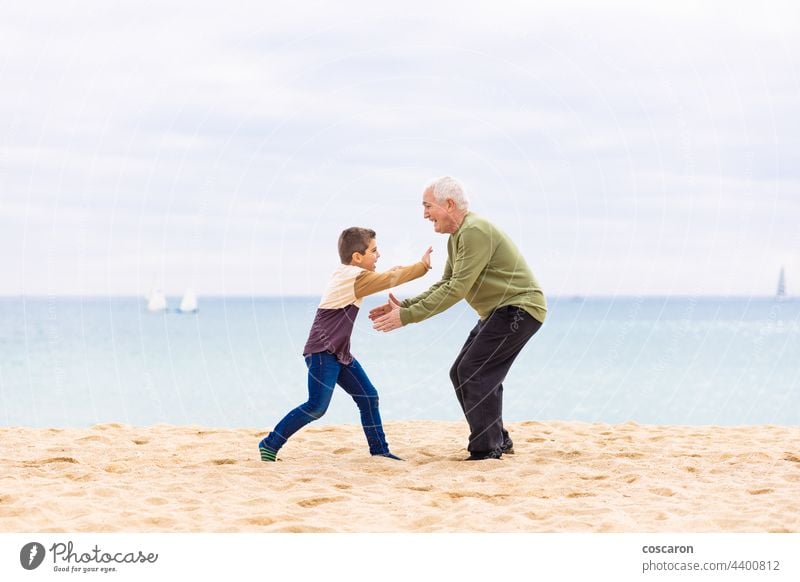 Fröhlicher Junge, der seinen Großvater am Strand umarmen will sorgenfrei heiter Kind Kindheit Kinder Papa älter Familie Vater Gefühl Spaß Generation Enkel