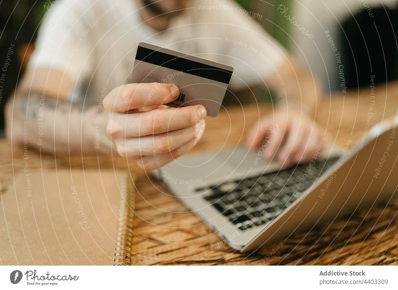 Crop-Mann beim Bezahlen mit Plastikkarte beim Online-Shopping Zahlung online Werkstatt Laptop Kauf bezahlen Orden Käufer e-Commerce Kunde verbrauchen Laden