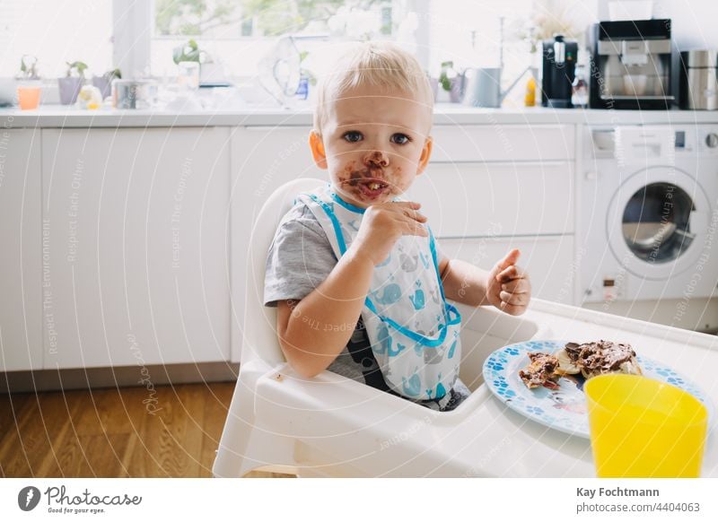 Entzückendes Kleinkind mit schokoladenverschmiertem Gesicht 12-23 Monate Sucht bezaubernd Baby blondes Haar blaue Augen Bonbon Kaukasier kaukasische Ethnizität