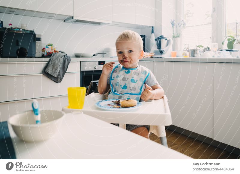 Entzückendes Kleinkind mit schokoladenverschmiertem Gesicht 12-23 Monate Sucht bezaubernd Baby blondes Haar blaue Augen Bonbon Kaukasier kaukasische Ethnizität