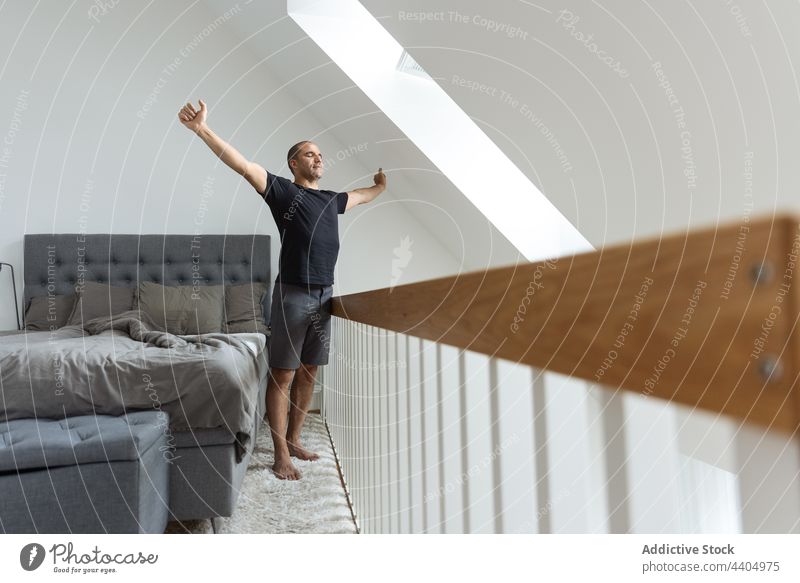 Mann streckt sich nach dem Aufwachen im Schlafzimmer Dehnung Morgen heimwärts Aufwärmen aufwachen Windstille früh männlich Bett stehen Energie friedlich Körper