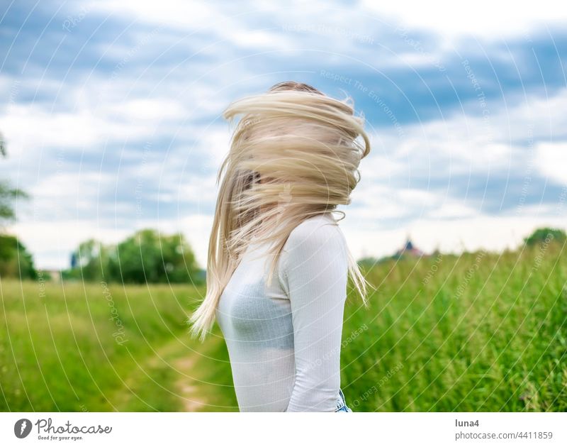 junge Frau mit zerzausten Haaren glücklich wehen Wind sinnlich windig anmutig hübsch single fröhlich Porträt attraktiv optimistisch entspannt blond Freude
