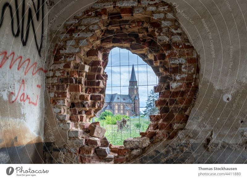 Kirche in Manheim, einem Dorf, das für den Braunkohletagebau abgerissen wird, Blick durch ein Loch in einer Backsteinmauer Verlassen Architektur