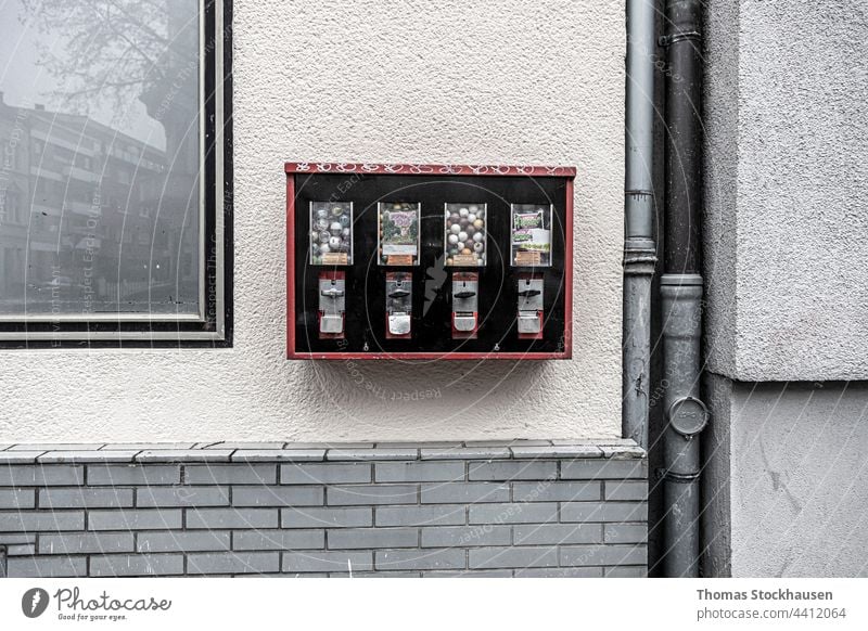 Kaugummi-Ball-Maschine an einer Wand befestigt, Abwasserrohr und Spiegelungen im Fenster Antiquität Architektur Automat automatisiert Automatisierung