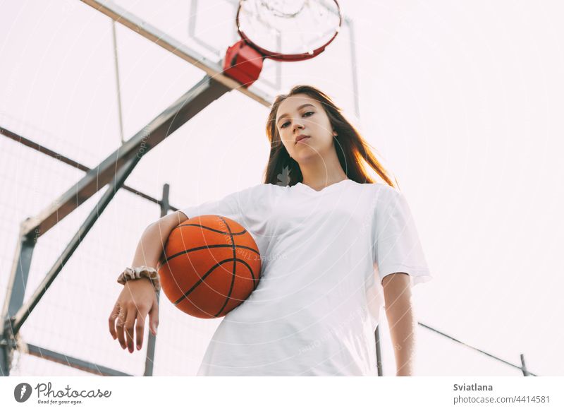 Porträt einer jungen Basketballspielerin. Schöne Teenager-Mädchen spielen Basketball. in Sportkleidung Basketball spielen Sportbekleidung Ball Korb Spieler