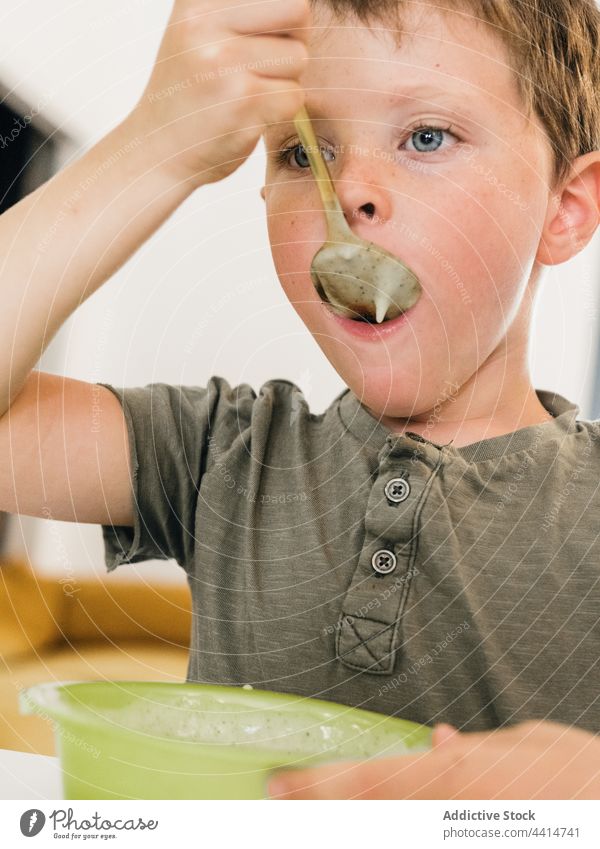 Kind mit Löffel isst Cremesuppe essen lutschen Mittagessen Sahne Suppe Junge Mahlzeit Lebensmittel heimwärts Speise geschmackvoll Küche niedlich lecker