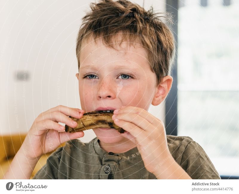 Hungriges Kind isst Schweinerippchen beim Mittagessen Schweinefleisch Rippe heimwärts Lebensmittel Junge appetitlich niedlich Mahlzeit bezaubernd genießen