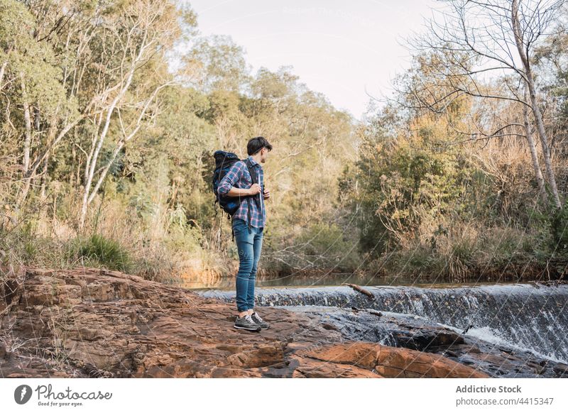 Reisender Mann steht in der Nähe eines kleinen Wasserfalls im Wald Rucksack Wanderer Trekking Wälder reisen Abenteuer männlich Natur erkunden Backpacker Umwelt