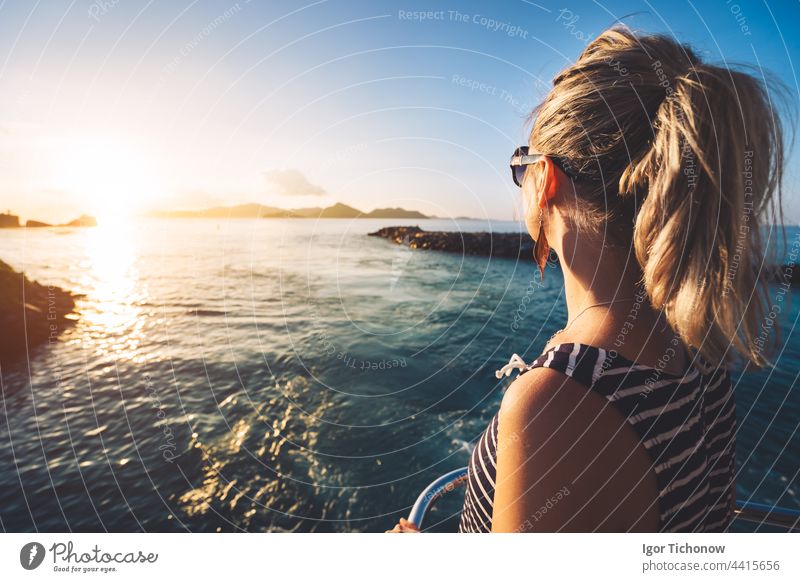Junge erwachsene Frauen genießen den Sonnenuntergang über dem Meer von der Fähre aus, Seychellen Insel, La Digue golden Silhouette Mädchen digue jung reisen