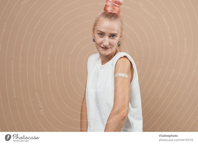 Junge Hipster-Frau mit Pflaster nach Coronavirus Covid-19-Impfung. Covid Impfung Konzept, einfarbigen Hintergrund COVID Impfstoff Einspritzung Arme jung