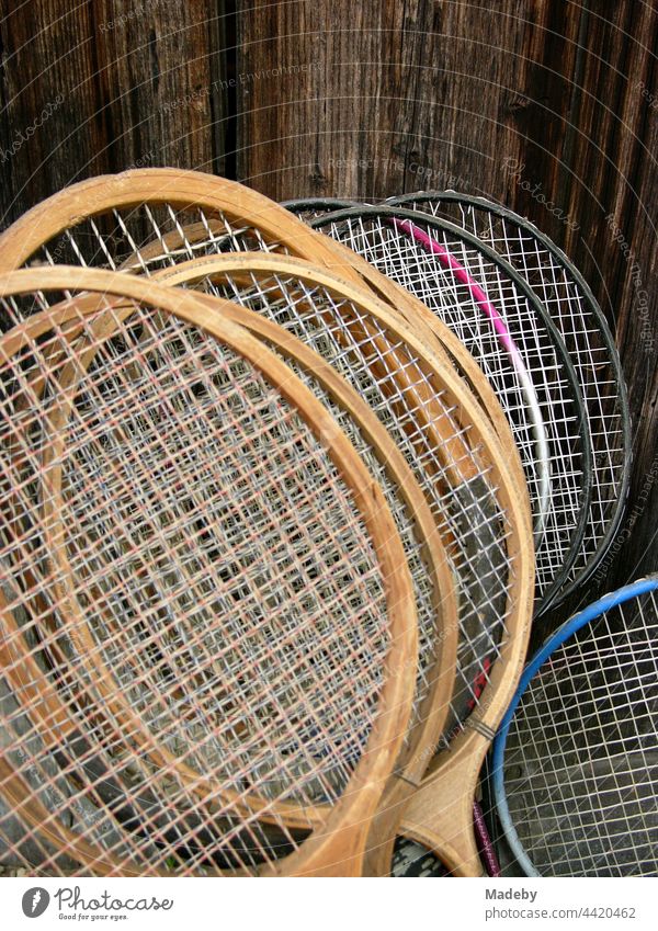 Bespannung von Schlähern für Federball oder Badminton im Sommer vor dem braunen Holz eines Schuppen im Garten eines Bauernhof in Rudersau bei Rottenbuch im Kreis Weilheim-Schongau in Oberbayern