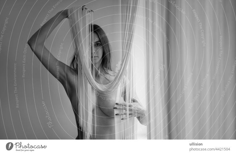nackter Körper einer jungen Frau, teilweise verdeckt durch einen herabfallenden Fadenvorhang, mit Kopierraum, Platz für Text. schwarz-weiß Schwarz-Weiß-Bild