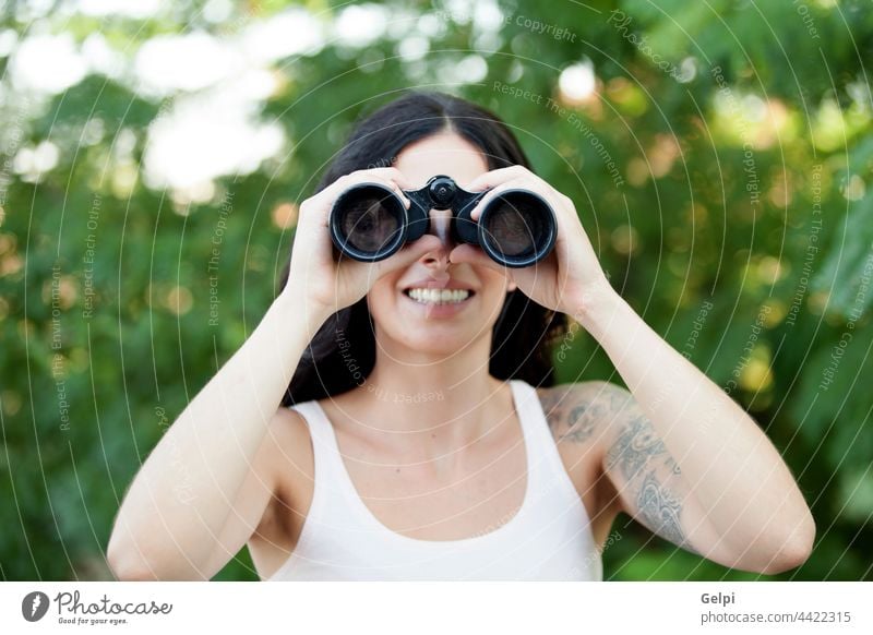 Brünette Frau schaut durch das Fernglas, während sie durch einen Wald spaziert wandern reisen Abenteuer Aktivität Wanderer Lifestyle Natur Wanderung Glück