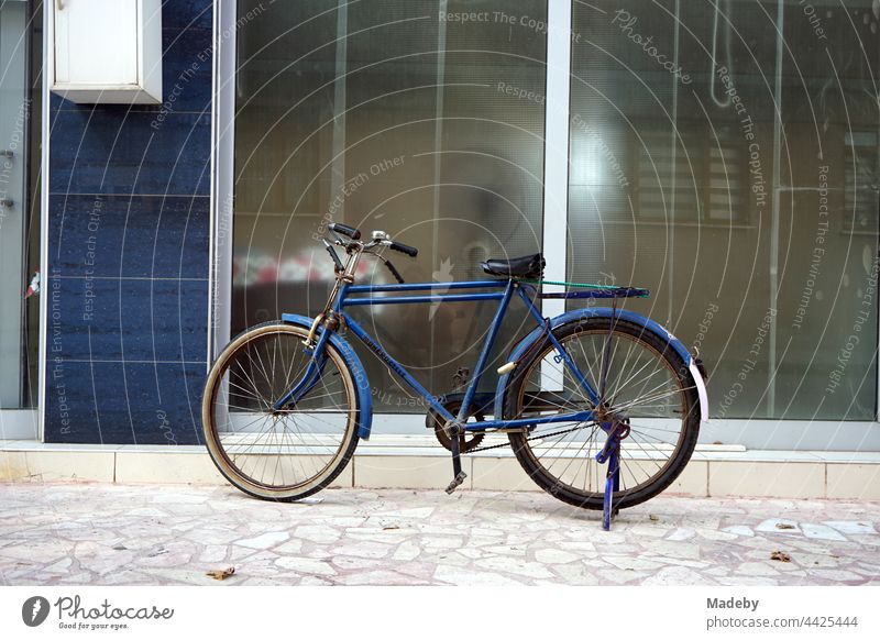 Altes blaues Fahrrad vor blauem Hauseingang mit viel Glas in Adapazari in der Provinz Sakarya in der Türkei Rad Herrenrad Tourenrad Stadtrad Radfahrer Radfahren