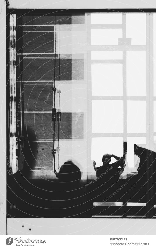 Menschliche Silhouetten vor einer geometrischen Fassade reflektieren in einer Glasscheibe Fenster Scheibe abstrakt Fotograf Reflexion & Spiegelung