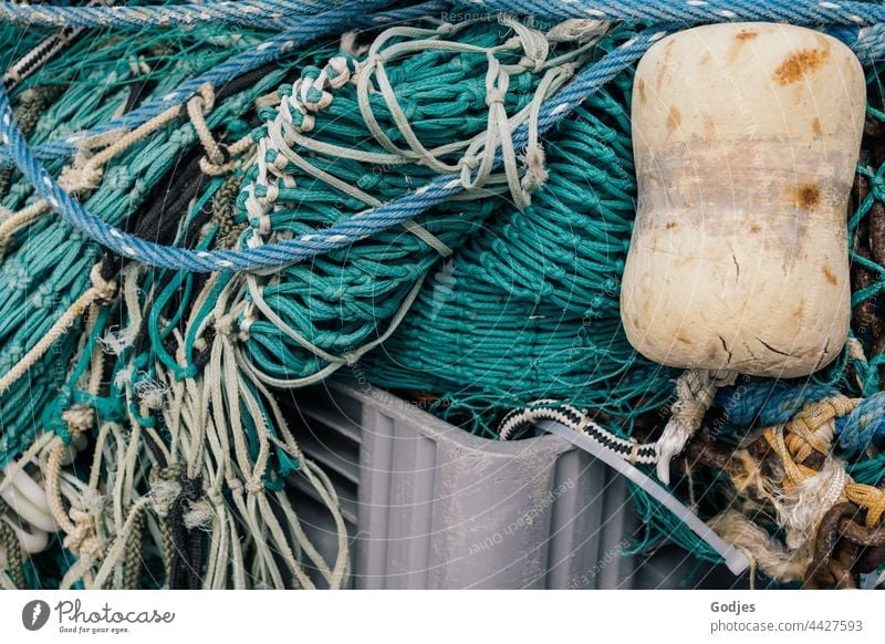 Fischernetz liegt zusammengelegt in einer Kiste | Ordnung im Chaos Fischerei Boje Netz Plastik Seil Außenaufnahme Farbfoto Fischereiwirtschaft Menschenleer
