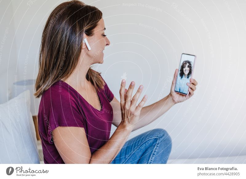 glückliche kaukasische Frau zu Hause tun Videoanruf mit Freunden auf dem Handy. Heimbüro und Freundschaft heimwärts Bett Kaukasier 30s Glück Lächeln schön jung