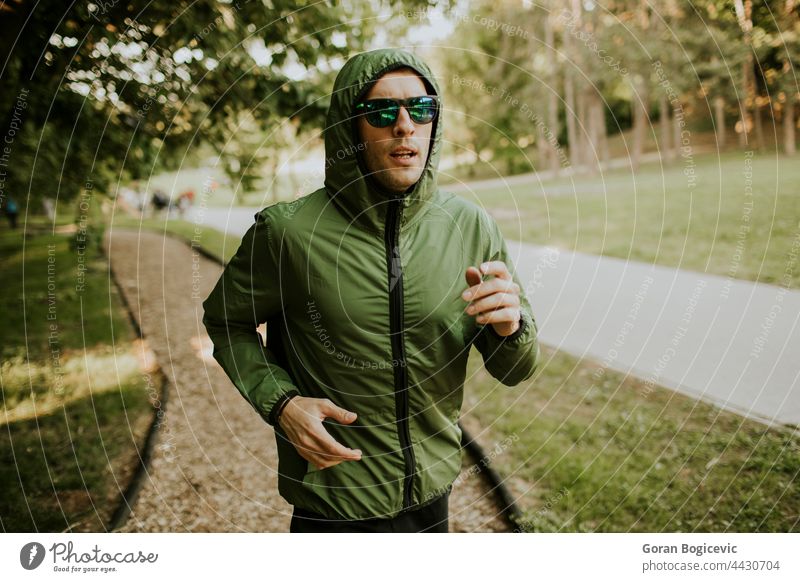 Sportlicher junger Mann, der in einem sonnigen grünen Park trainiert Aktion aktiv Aktivität Erwachsener Athlet sportlich Kaukasier Ausdauer Übung passen Fitness