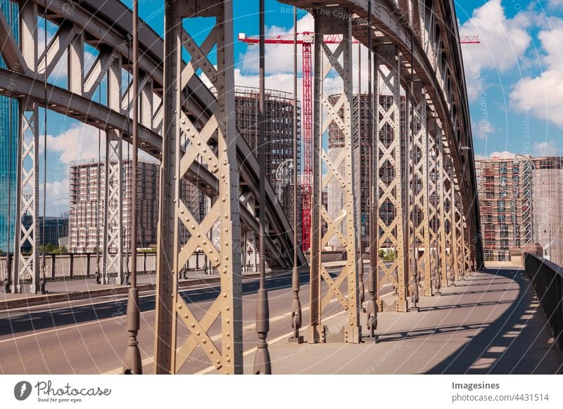 Bogenbrücke Honsellbrücke und Frankfurter Innenstadt Ostend. Luxuswohnungen im Bau mit Kran. Wolkenkratzer-Gebäude auf der Baustelle. Frankfurt am Main, Deutschland