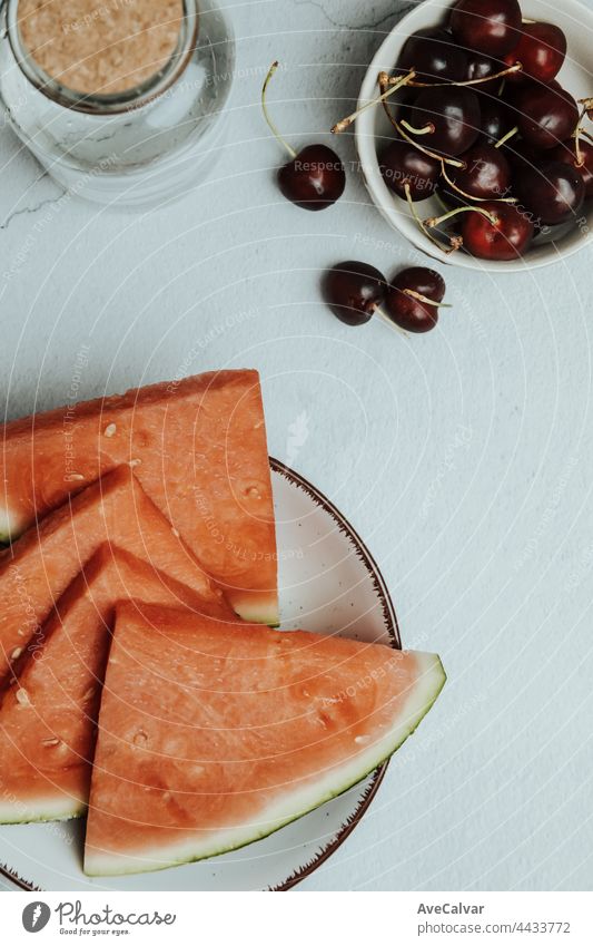 Haufen von Sommer und frischen Früchten über einem minimalistischen weißen Tisch, Wassermelone und Kirsche, Wellness und gesunde Ernährung Konzepte, schmackhaft, texturiert, Kopie Raum