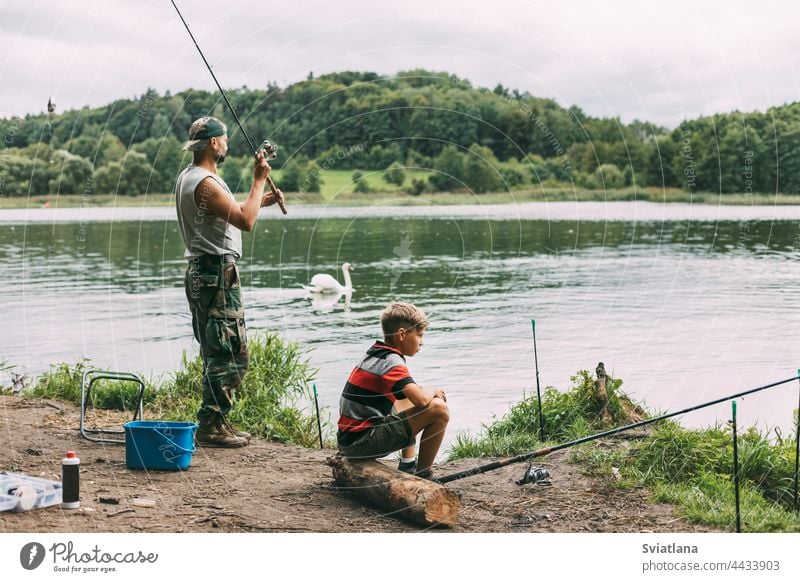 Ein junger Mann bringt seinen Kindern während eines Familienurlaubs auf einem Campingplatz das Angeln bei. Hobbys, Urlaub, Wochenenden, Angeln Fischen