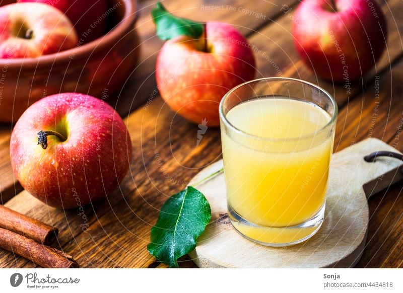 Frischer Apfelsaft im Glas und rote Äpfel auf einem Holztisch Trinkglas Herbst frisch lecker Bioprodukte Innenaufnahme Gesunde Ernährung Gesundheit natürlich