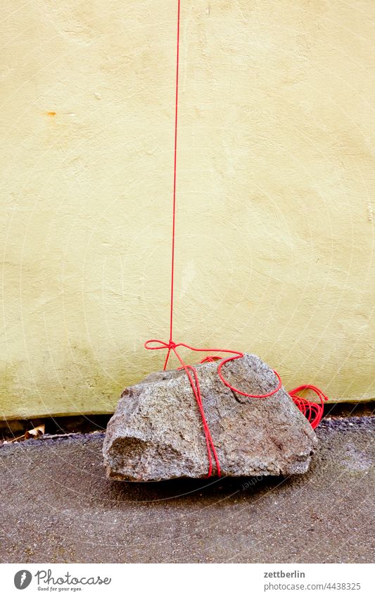 Festgebunden stein fels brocken felsbrocken seil schnur strick befestigung knoten sicherheit vorsicht wind wehen wand haus leine festmacher festmachen anbinden