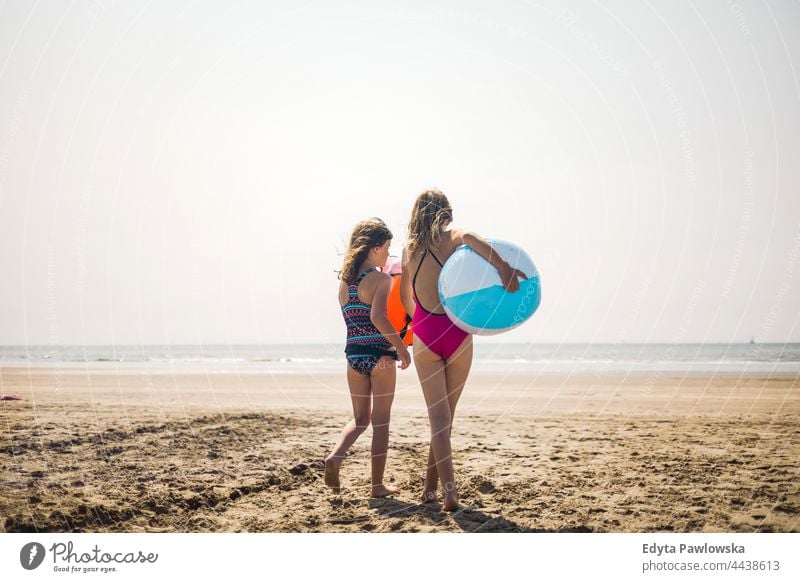 Zwei Kinder am Strand mit einem aufblasbaren Ball echte Menschen authentisch MEER Meer Sand Himmel Wasser aufblasbarer Ball Spielzeug Urlaub reisen aktiv