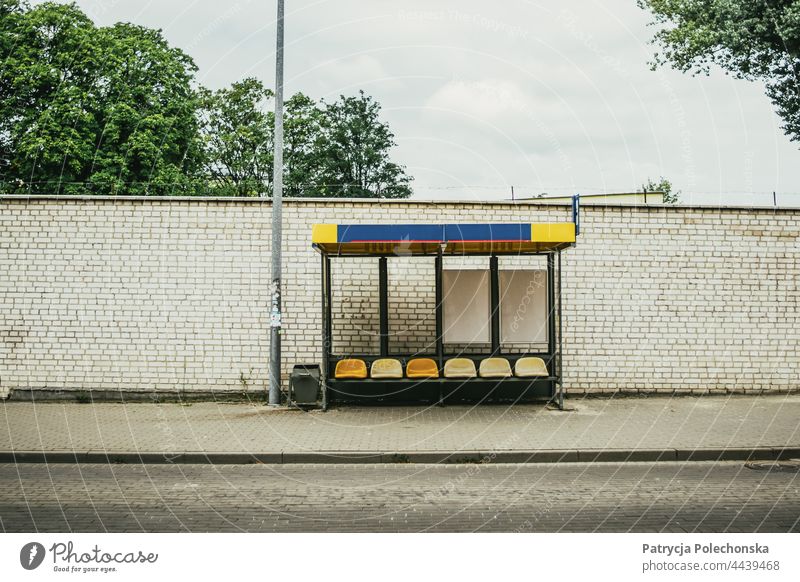 Leere Bushaltestelle vor einer grauen Backsteinmauer an der Straße Öffentlicher Personennahverkehr öffentlicher Verkehr Wand Baustein leer Großstadt Transport