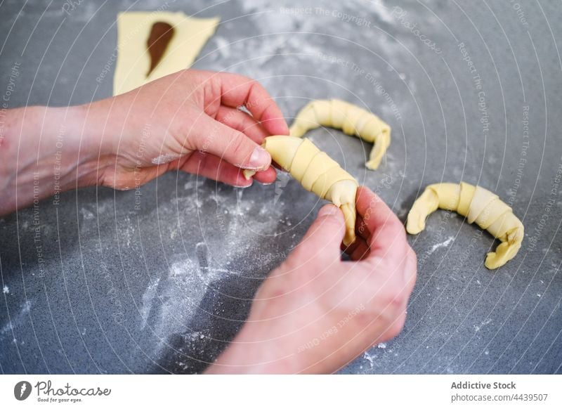 Bäcker bereitet kleine Croissants mit Schokolade zu Person Konditorei Küche Tisch Lebensmittel Koch Dessert süß vorbereiten selbstgemacht kulinarisch Gebäck
