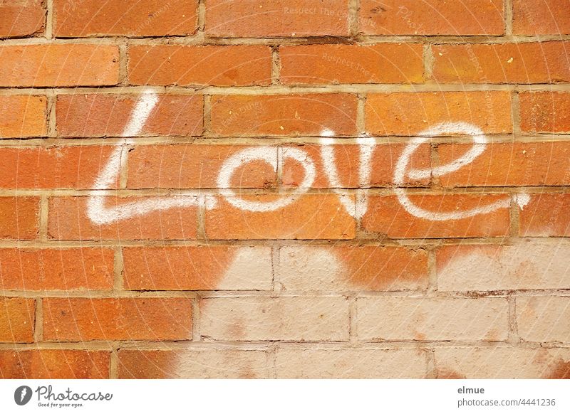 Love steht in weißen Buchstaben an der roten Ziegelmauer / Graffito love Liebe Graffiti Schrift sprayen Wort englisch Liebeserklärung Liebesbeweis Kreativität