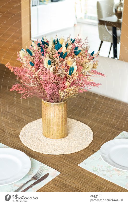 Teller und Utensilien, auf dem mit einem kleinen Blumenarrangement geschmückten Tisch Borte Kernstück Stoffserviette konzeptionell Zeitgenosse Textfreiraum
