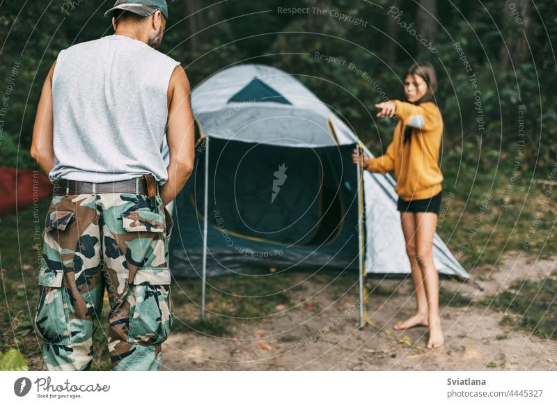 Ein glücklicher Vater und seine Tochter bauen ein Campingzelt auf. Familienzeit, Familienerholung, Pflege Zelt Installation Glück wenig männlich Eltern