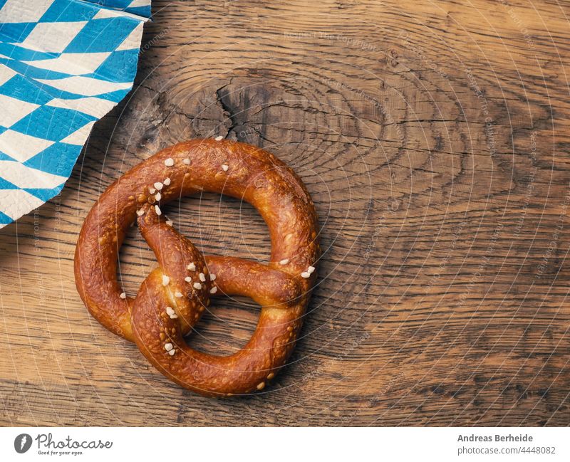 Leckere Brezel mit bayerischer Fahne auf einem rustikalen Holztisch Deutschland München Oktoberfest Bayern verdrillt knackig Originalität Gebäck lecker