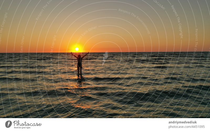 Silhouette eines entspannten jungen Mädchens in einem Badeanzug im Meer bei Sonnenaufgang. Glücklich Urlaub Urlaub Konzept. Frau MEER Strand Sonnenuntergang