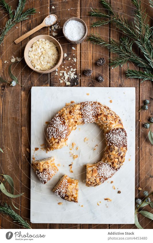 Königskuchen mit Mandelblättern und Kokosraspeln Dessert Leckerbissen Kokosnuss süß geschmackvoll Epiphanie Festessen feiern lecker Feiertag Spielfigur Zweig