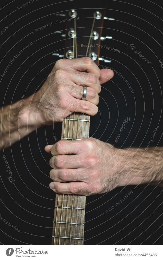 Musiker mit einer Gitarre in den Händen Gitarrensteg festhalten Leidenschaft musizieren Musikinstrument Kultur