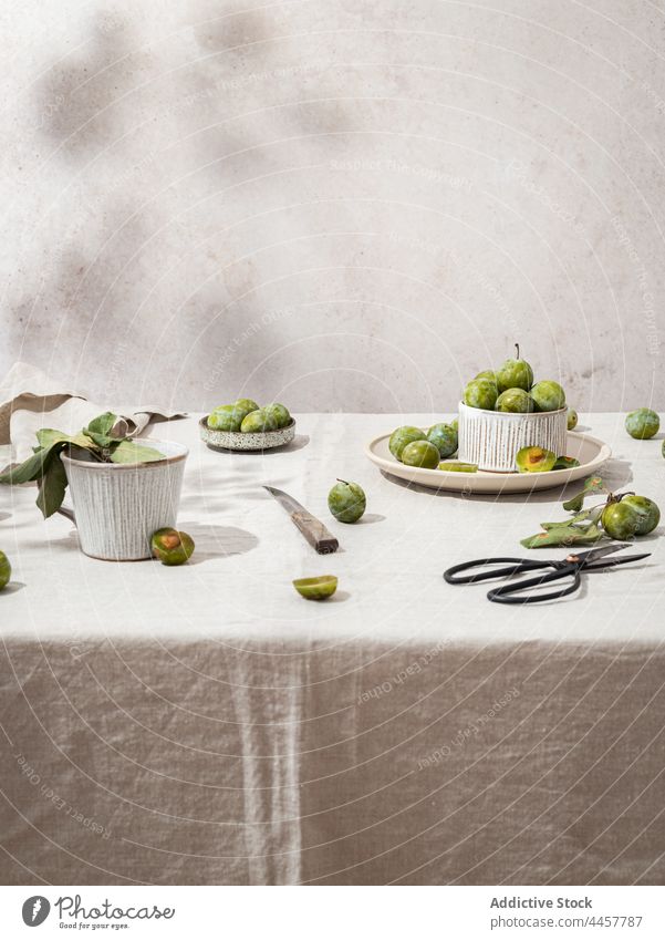 Grüne Pflaumen auf dem Tisch angeordnet Stillleben grün rustikal kreativ Geschirr frisch reif Teller Schalen & Schüsseln Gesundheit Zusammensetzung Lebensmittel