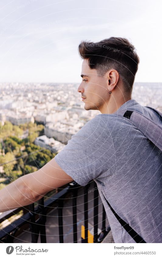 Tourist, der Paris vom Eiffelturm aus betrachtet nachdenken Turm Mann Höhe Gebäude reisen Tourismus Textfreiraum Rucksack Frankreich wandern betrachtend