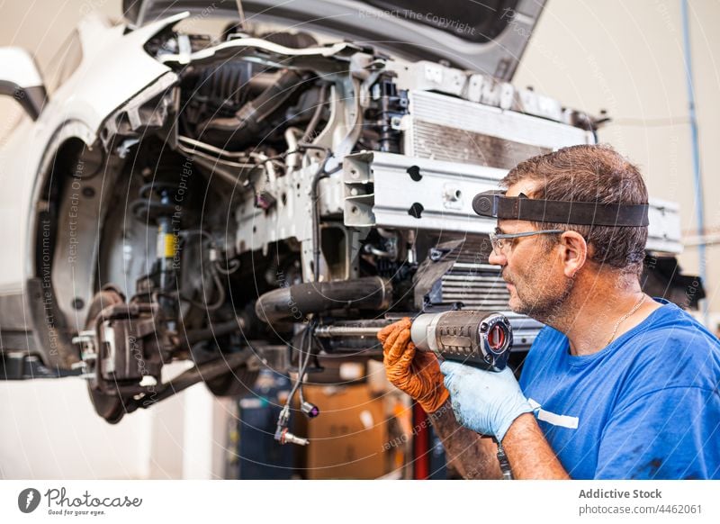 Kfz-Mechaniker bei Reparatur von Motor in Auto-Werkstatt Stock Photo