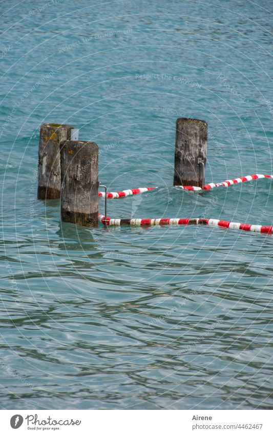 irgendwie irgendwas begrenzen See Absperrung Schutzmaßnahme Pfosten Holzpfosten rotweiß Signalfarben Sicherheit Wasser Wellen schwimmen Nichtschwimmerbereich