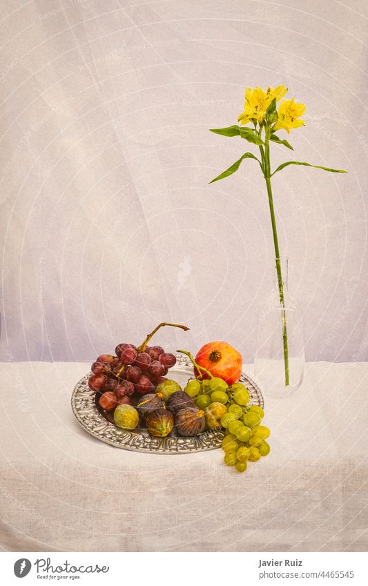 Blumen- und Früchtestillleben auf erdfarbenem Hintergrund, mit Trauben, Feigen, einem Granatapfel auf einem Silberteller und einer gelben Blume in einem Glasgefäß
