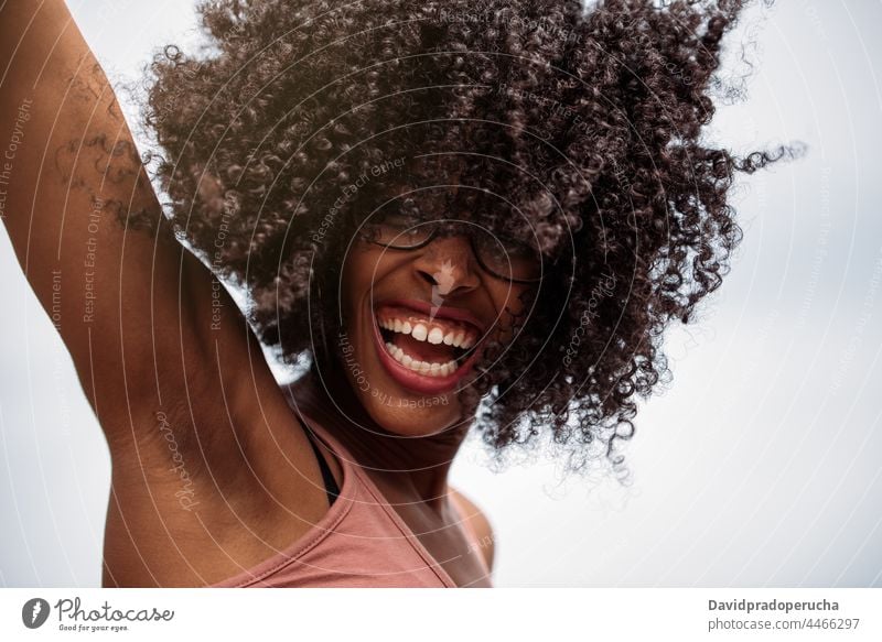 Glückliche ethnische Frau mit lockigem Haar Afroamerikaner Frisur wild Freude Santo Antão Kap Verde Cabo Verde Afrika jung Lachen aufgeregt freudig heiter