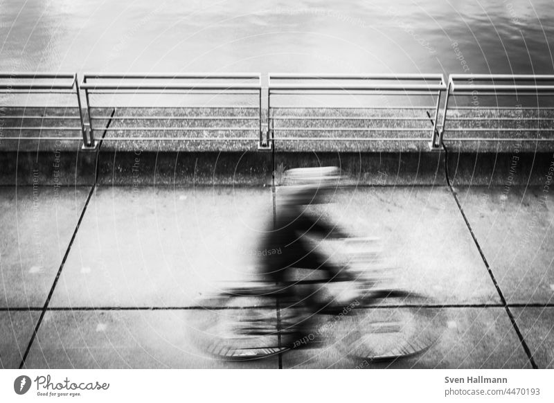 unscharfer Radfahrer in Bewegung bike Fahrrad Minimalismus Langzeitbelichtung abstrakt Silhouette linien urban Radfahren Biker defokussiert Übung Fahrradfahren