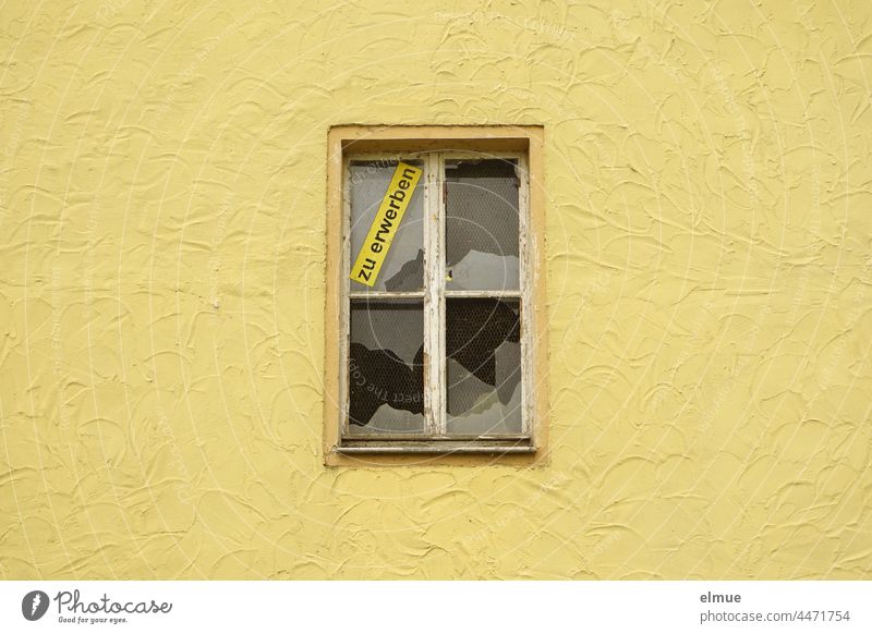eine gelbe Hauswand mit einem zerschlagenen Fenster und dem Schild  - zu erwerben - Immobilie Immobilienmarkt Glasscheibe kaputt Fassade Häusliches Leben wohnen