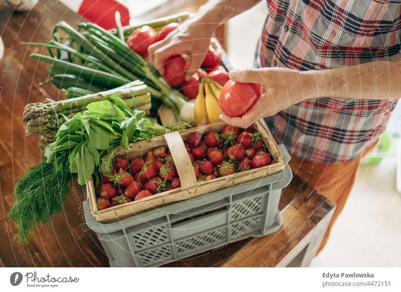 Mann beim Auspacken seiner Einkäufe in der Küche zu Hause Hand Menschen Person Auspacken von Lebensmitteln Ackerbau Spargel Korb Kasten kaufen Essen zubereiten