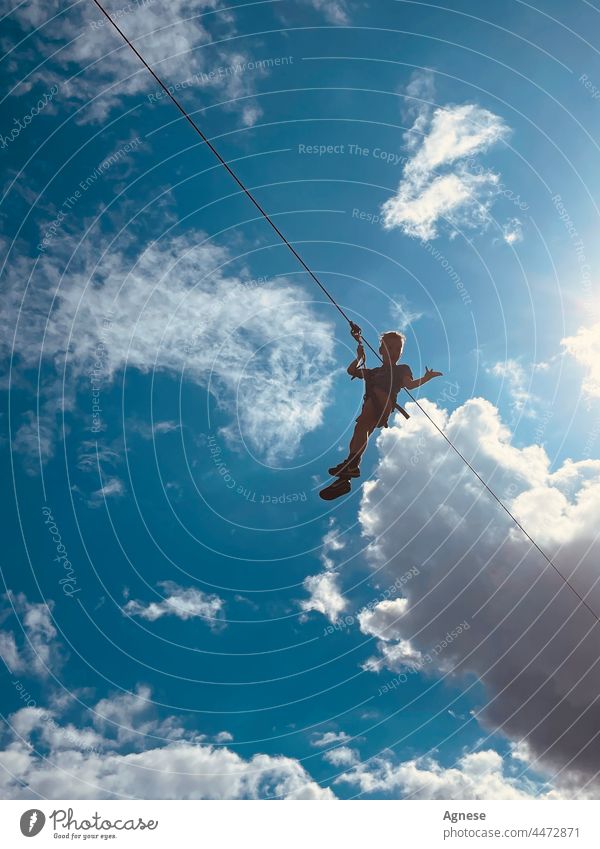 Fliegender Junge am Himmel. Seilbahn. fliegen Blauer Himmel Wolken Kind aktiv Sommerhimmel Spaß aktiver Lebensstil