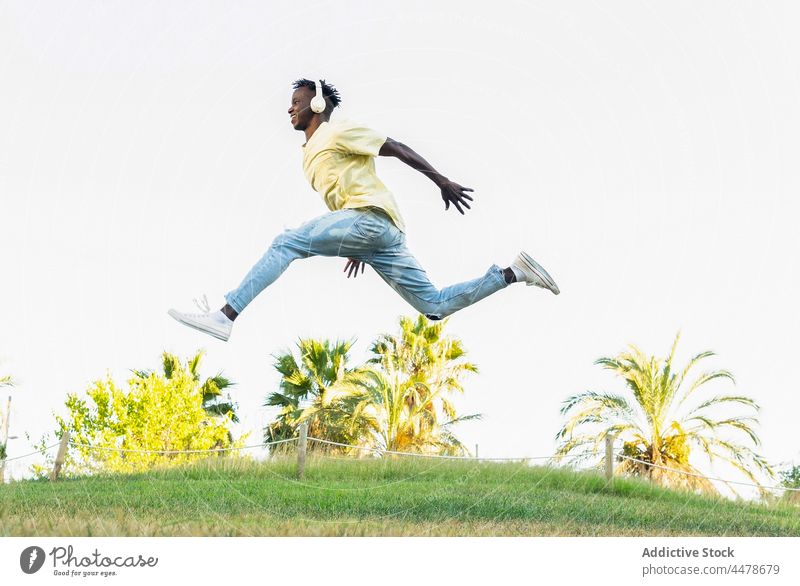 Energetischer schwarzer Mann springt mit Split im Park springen Freiheit Aktivität Energie lässig aktiv Outfit Sprung Lifestyle Trick Bewegung Stil Sommer