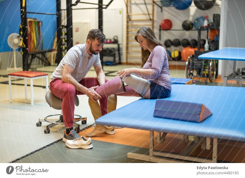 Physiotherapeutin hilft junger Frau mit Beinprothese Physiotherapie Tatkraft Wiederherstellung Rehabilitation Stärke Training Beine Übung Fitness Sport