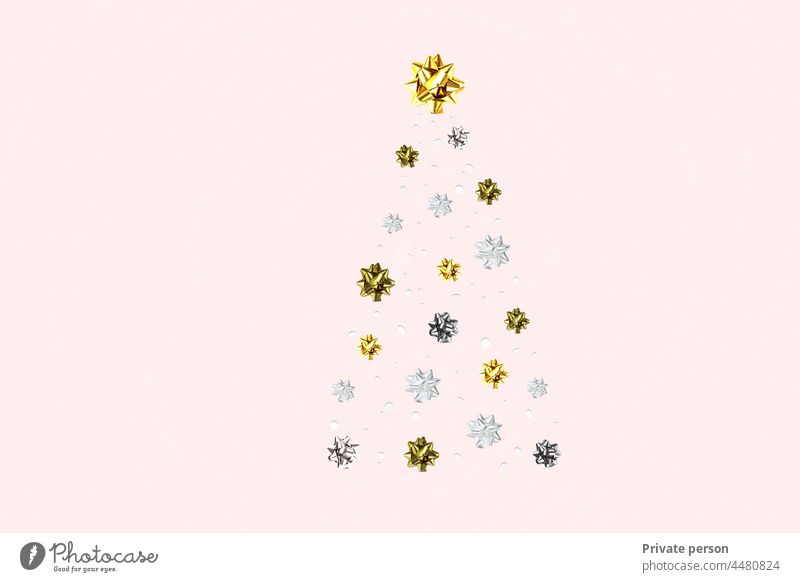 Weihnachtsbaum auf einem rosa Hintergrund. Goldener Weihnachtsbaum als Symbol für ein glückliches neues Jahr, Weihnachtsfeier. Goldenes Licht Dekoration. glänzende neue Jahr Grußkarte Design in Pastellfarben